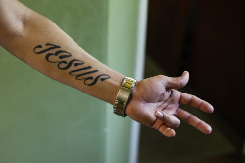 Iranian asylum-seeker Mohammed Ali Zanoobi shows his "Jesus" tattoo prior to being baptized in a service in the Trinity Church in Berlin, Aug. 30, 2015.